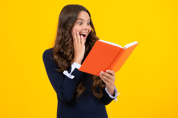 Excited face. Back to school. Teenager schoolgirl with book ready to learn. School girl children on isolated yellow studio background. Amazed expression, cheerful and glad.