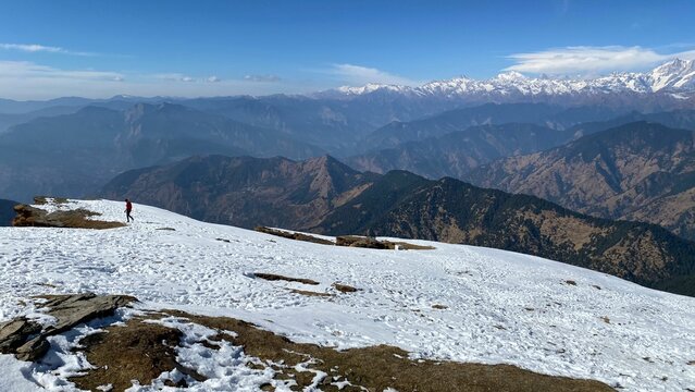 Scenic view of the mountains from the top of another one covered with snow on a winter day