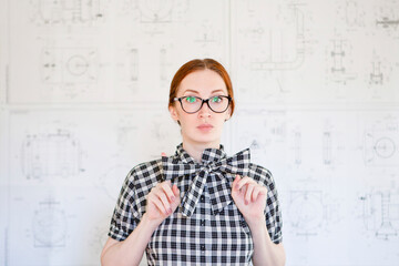 young woman engineer with mechanical drawings on background
