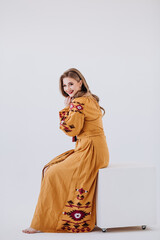Young beautiful smiling girl in a long embroider dress. Traditional Ukrainian wear Vyshyvanka....