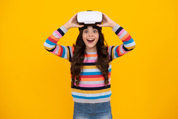 Obraz na płótnie Canvas Excited teenager using VR headset. Kid play vr video game. Digital future and innovation. Child in virtual goggles. Excited teen girl with virtual reality goggles headset isolated on yellow.