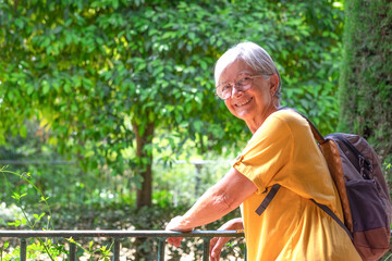 Caucasian senior tourist woman in yellow jersey visiting gardens of Alcazar, a historic famous...