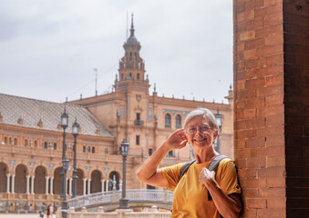 Happy senior woman traveling in Seville, Spain visiting famous places - attractive elderly traveler...