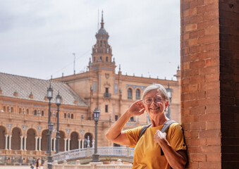 Obraz premium Happy senior woman traveling in Seville, Spain visiting famous places - attractive elderly traveler enjoying summer and cultural vacation