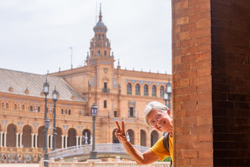 Fototapeta na wymiar Happy senior woman traveling in Seville, Spain visiting famous places - attractive elderly traveler enjoying summer and cultural vacation