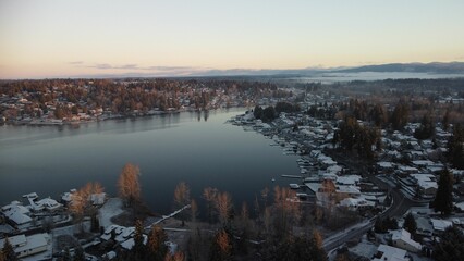Aerial drone view of Lake Stevens surrounded by trees and houses in winter