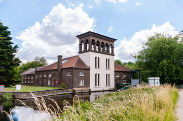 Visitors passing by the Coppermill Tower at Walthamstow Wetlands, Waltham Forest, London, United Kingdom, 3 July 2022