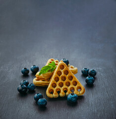 Homemade waffles with strawberries and blueberries. Delicious Breakfast with berries. Dark background. Banner.