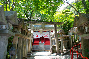 Traditional stone gate to temple - shrine with tree foliage