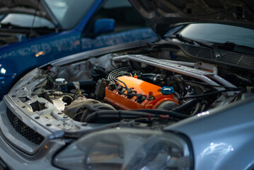 Close-up of an orange engine under the hood of a Japanese car. Powerful motor in a stylish car.