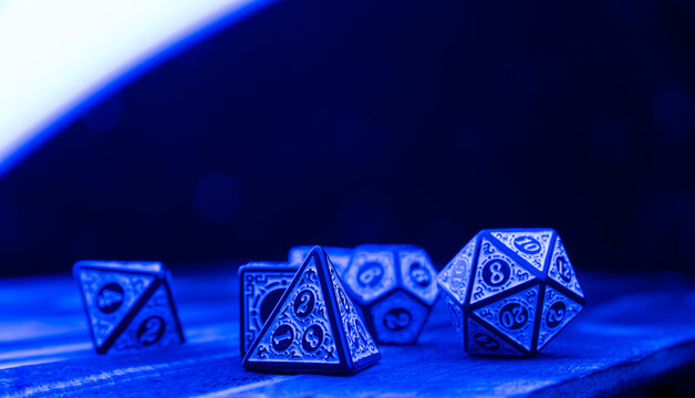 RPG dice illuminated with colored light, light painting style photo, selective focus.