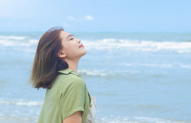 Portrait of an Asian woman relaxing and having fun on the beach in holiday