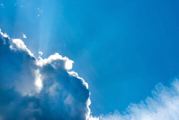 Light ray from sun behind cloud in the blue sky © Таня Мигунова