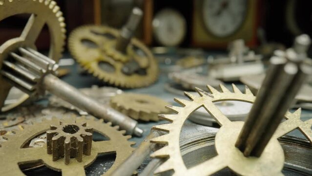 Pile of metal internal parts of an old clock. Dial, clockwork, bracelet, gears, cogwheels on blurred clock background. Disassembled clock mechanism of an old watch. Clock workshop, repair. Close up.