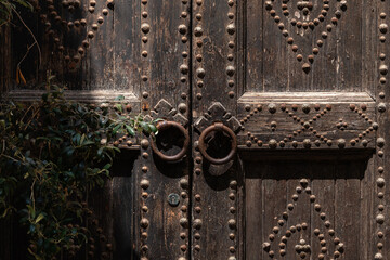 Background with an ancient wooden door with metallic round knobs