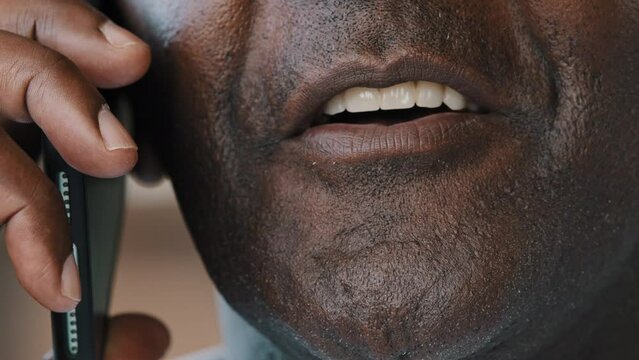 Extreme close up unknown unrecognizable male face african american adult senior 60s man businessman grandfather client shopper talk mobile phone make internet order consult remote use telephone gadget