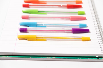 coloured pens placed on a blank notebook