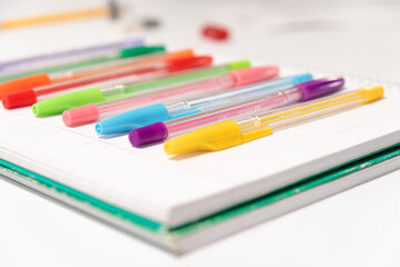 coloured pens placed on a blank notebook