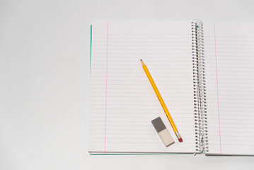 school equipment on open blank notebook