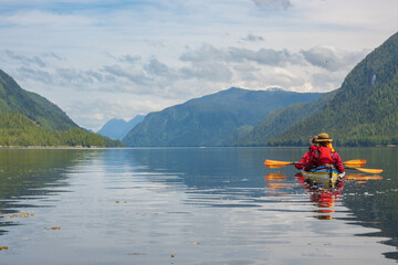 Se kayakers in a tandem look down a passage in Hieltsuk Territory on the Central Coast of British Columbia..  Room for text.