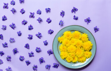 Yellow dandelion flowers in a plate on a lilac background. flower background
