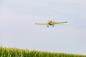 Crop duster airplane spraying chemicals on cornfield. Fungicide, pesticide and crop spraying...
