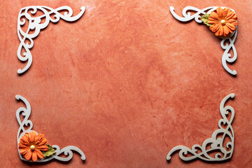 frame with wood cutouts and paper flowers on orange textured background