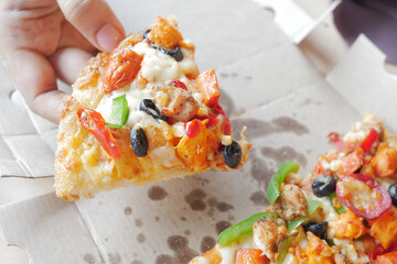  holding cheese pizza on take away packet 