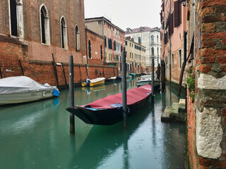 Fototapeta na wymiar Canal of Venice with a Gondolas and a boats