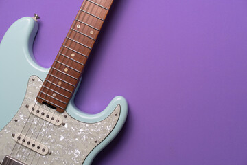 Obraz premium Electric guitar on purple table background, close up music concept