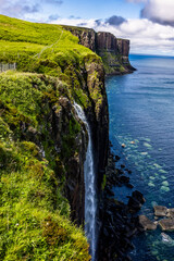 Kilt Rock and Mealt Falls. The waterfall free falls 60 metres from the cliff top down onto the shore below. The sea below can appear turquoise in sunny conditions or steely grey in cloudy weather.