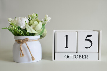 October 15, Cover natural background, white wooden Calendar cube with a pot flower on white background.