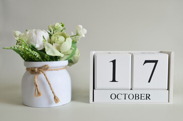 October 17, Cover natural background, white wooden Calendar cube with a pot flower on white...