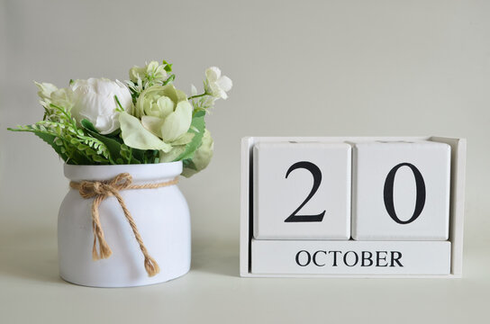 October 20, Cover natural background, white wooden Calendar cube with a pot flower on white background.