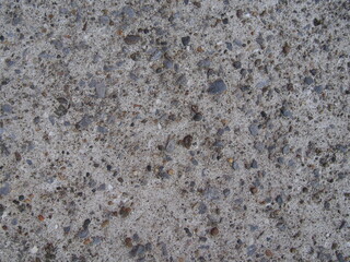 大き目の小石が混じる、白色のざらざらしたコンクリートのテクスチャー