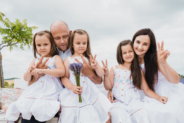 Happy cheerful family in nature, weekend. Dad, mom and three children all in clothes, having a good time. Concept of a strong family. Emotions of happiness.