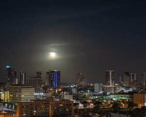 Fototapeta premium Moon Over a City at Night.
