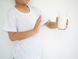Cute kid refusing to drink milk. lactose intolerance. closeup photo, blurred.
