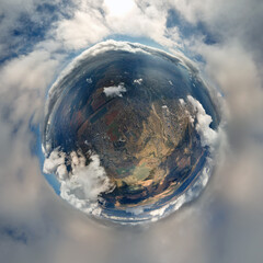 Aerial view from high altitude of little planet earth covered with white puffy cumulus clouds on...