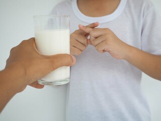 Cute kid refusing to drink milk. lactose intolerance. closeup photo, blurred.