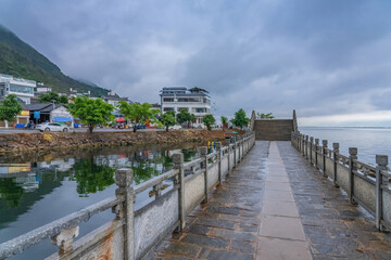 Obraz premium The street view and the natural landscape of the ancient stone arch bridge on the Erhai sea in Yunnan Province, China