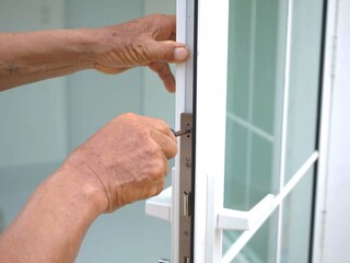 Man is installing the part of the wooden door by the screwdriver. closeup photo, blurred.