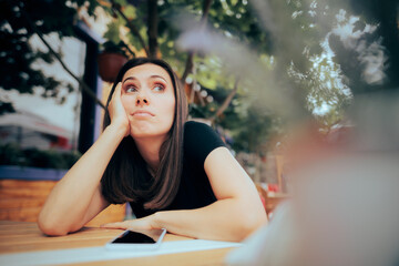 Bored Woman Waiting a Phone Call in a Restaurant. Lonely woman feeling depressed and disappointed...