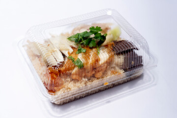 Side view of plastic box for food of Hainanese chicken glutinous rice mix with Fried Chicken. On white floor or isolated white background.