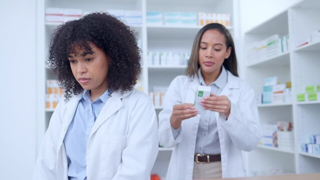 Two pharmacists updating their stock system and taking inventory together in a pharmacy. Female chemist manager working on computer and while training an intern or trainee on medication in drugstore