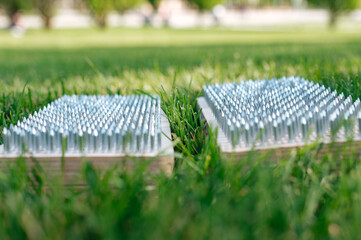 Closeup view of sadhu wooden board for yoga practice in grass. Nailing practice