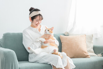 家で猫を抱っこする日本人女性（ペット・飼い主）
