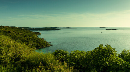 Sea landscape, islands in the horizon, a long coastline covered with vegetation