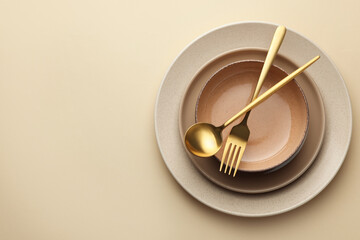 Stylish empty dishware and cutlery on beige background, top view. Space for text - obrazy, fototapety, plakaty