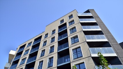 Exterior of new apartment buildings on a blue cloudy sky background. No people. Real estate business concept.